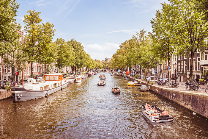 Amsterdam’s Canals, summer canal life Amsterdam, Stefanie Pietschmann Photographer, boats on Amsterdam waterways, Pietschy Photography, vibrant summer cityscape, Dutch canal lifestyle, fleeting summer moments, sustainable wall art, storytelling photograph