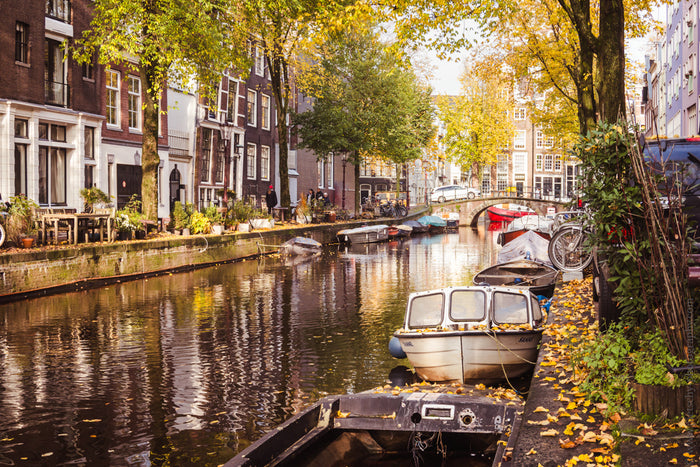 Autumn at Amsterdam’s Canals, fall colors Amsterdam, Stefanie Pietschmann Photographer, seasonal city photography, Pietschy Photography, autumn reflections in canals, picturesque Amsterdam scenery, golden season cityscape, sustainable wall art, storytelli