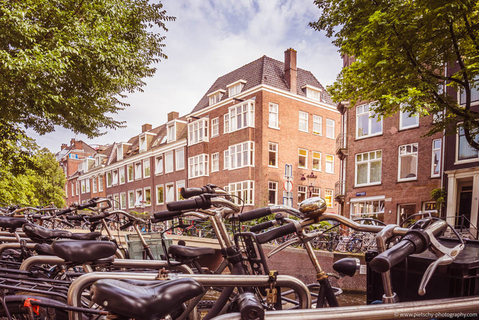 Amsterdam bicycles, bikes in Amsterdam, Amsterdam canal bridge bikes, Amsterdam street photography, Amsterdam canal houses, cycling culture Amsterdam, bicycles parked Amsterdam, Amsterdam city life, Netherlands cycling culture, Amsterdam travel photograph