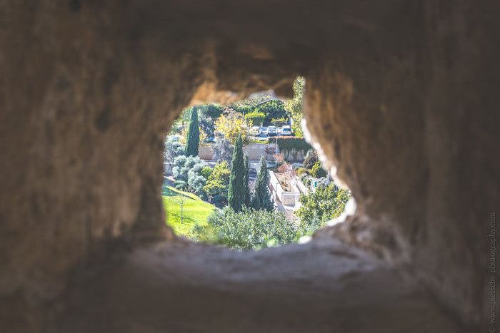 Jerusalem's Old City, Stefanie Pietschmann Photography,  View of Mitchell Park through a stone opening at the Tower of David in Jerusalem, capturing lush greenery framed by ancient walls, Stefanie Pietschmann Photography: