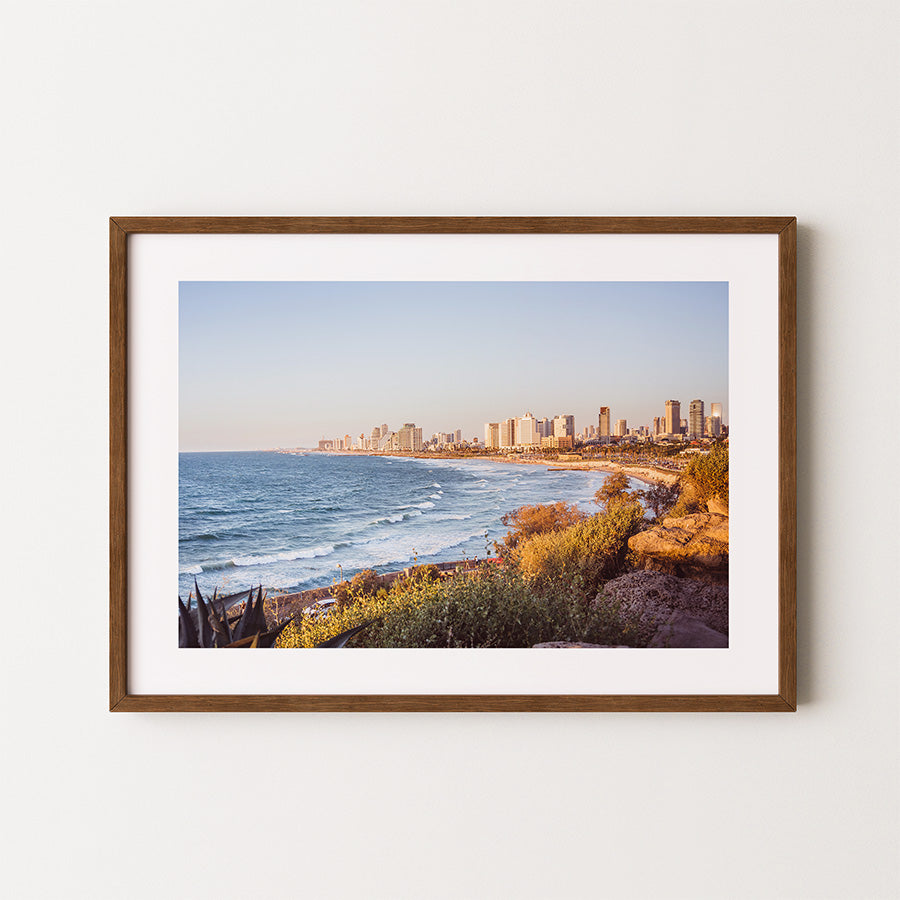 This Tel Aviv beach wall art captures the peaceful yet vibrant Mediterranean coastline where city meets sea, bathed in warm golden light. A fine art print that brings calm and inspiration into any space.
