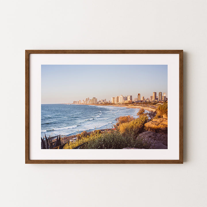 This Tel Aviv beach wall art captures the peaceful yet vibrant Mediterranean coastline where city meets sea, bathed in warm golden light. A fine art print that brings calm and inspiration into any space.
